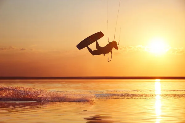 Kitesurfer at sunset with jump — Stock Photo, Image