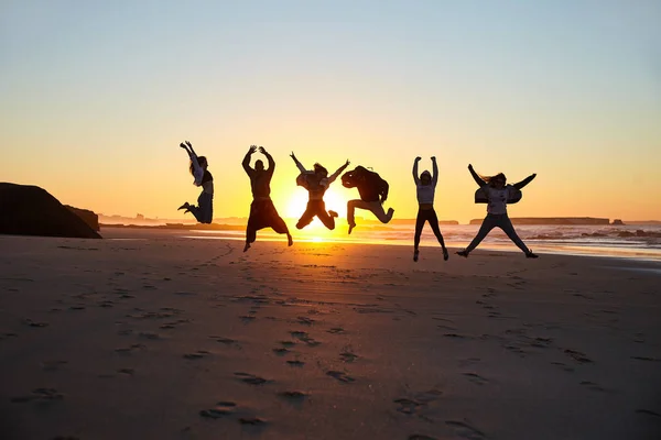 Silhuetas de amigos na praia — Fotografia de Stock