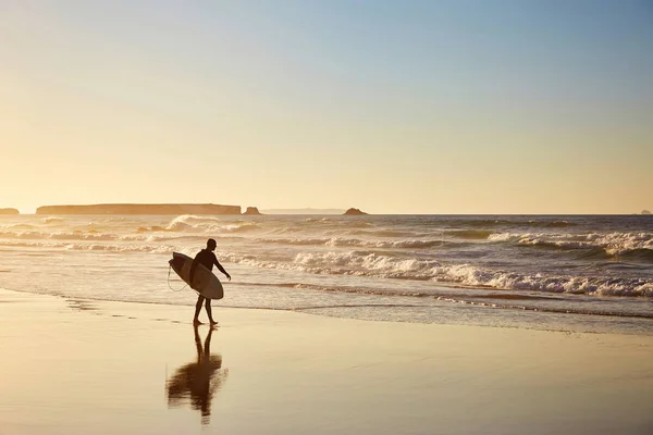 Серфер ходить уздовж сонячного узбережжя — стокове фото