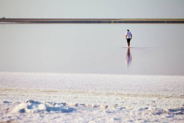adam beyaz plajda yürüyor
