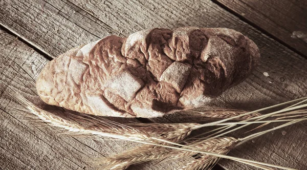 Freshly baked traditional bread on wooden table — Stock Photo, Image