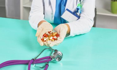 Kadın doktor, iş yerinde farklı tablet şişliklerinden oluşan el çantası tutuyor. Panacea, hayat kurtarma servisi, ilaç reçetesi, yasal eczane, hastalık tedavisi, tansiyon konsepti. Posta kutusu görünümü