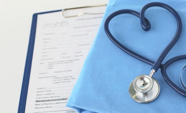 Un estetoscopio dando forma a un corazón en un uniforme médico, primer plano, enfoque selectivo —  Fotos de Stock