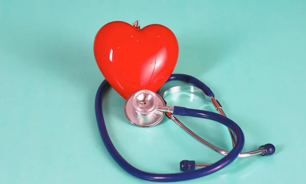 Red heart with stethoscope on blue wooden background. Copy space. Valentines day. — Stock Photo, Image