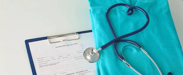 Un estetoscopio dando forma a un corazón en un uniforme médico, primer plano, enfoque selectivo —  Fotos de Stock