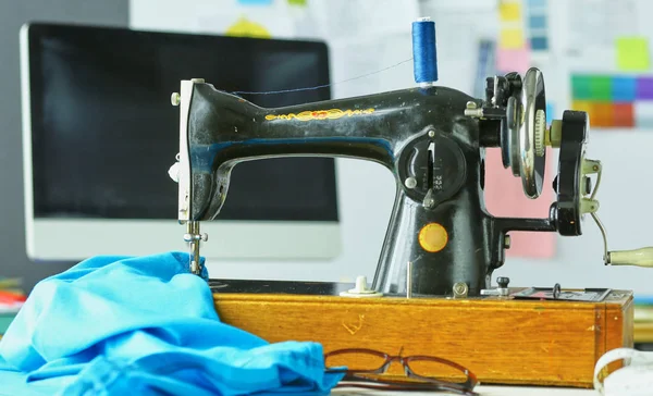 Retro sewing machine on designer clothes desktop