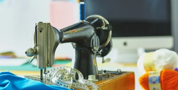 Retro sewing machine on designer clothes desktop