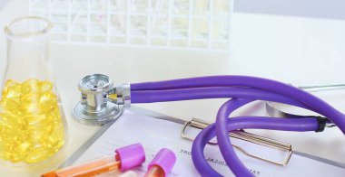 bir doktor ofisi ile bir stetoskop ön planda ve arka planda hapları bir şişeyle Resepsiyon closeup