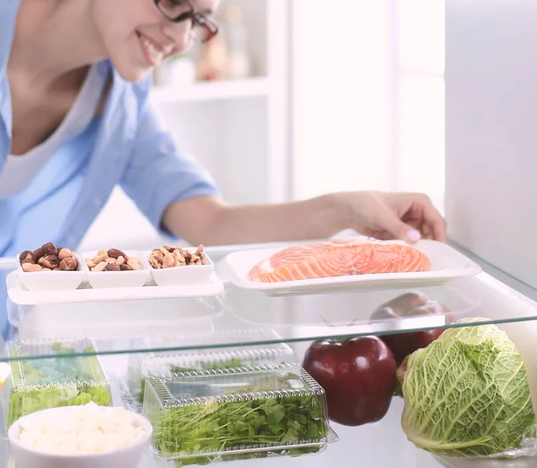 Mujer feliz con verduras en frente de refrigerador abierto —  Fotos de Stock