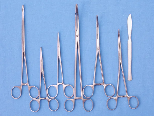 Ameliyat için masaya yerleştirilmiş neşter, pens ve cımbız gibi cerrahi aletler ve aletler.