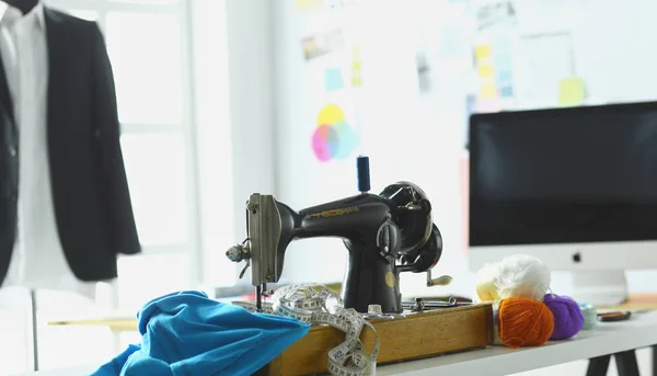 Retro sewing machine on designer clothes desktop