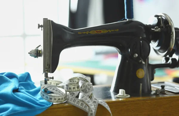 复古缝制机在设计师服装桌面上 — 图库照片