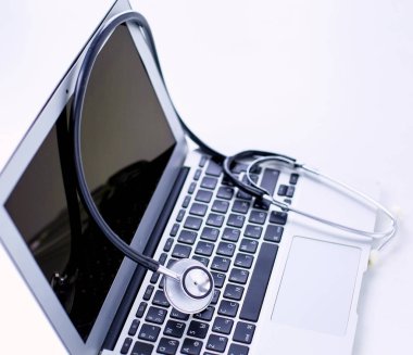 Bir dizüstü bilgisayar klavye online tıp kavramı içinde yatan veya bilgisayar sorun giderme stetoskop düşük açılı kopya alanı ile görüntülendi