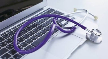 Bir dizüstü bilgisayar klavye online tıp kavramı içinde yatan veya bilgisayar sorun giderme stetoskop düşük açılı kopya alanı ile görüntülendi