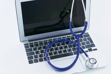 Bir dizüstü bilgisayar klavye online tıp kavramı içinde yatan veya bilgisayar sorun giderme stetoskop düşük açılı kopya alanı ile görüntülendi