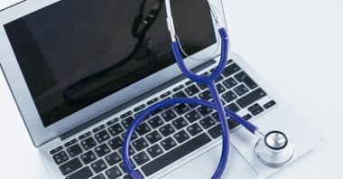 Bir dizüstü bilgisayar klavye online tıp kavramı içinde yatan veya bilgisayar sorun giderme stetoskop düşük açılı kopya alanı ile görüntülendi