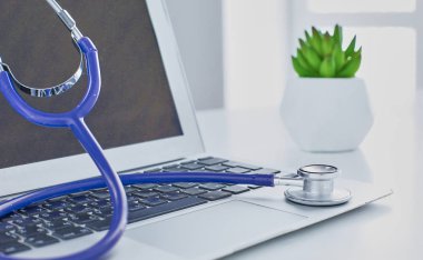 Bir dizüstü bilgisayar klavye online tıp kavramı içinde yatan veya bilgisayar sorun giderme stetoskop düşük açılı kopya alanı ile görüntülendi