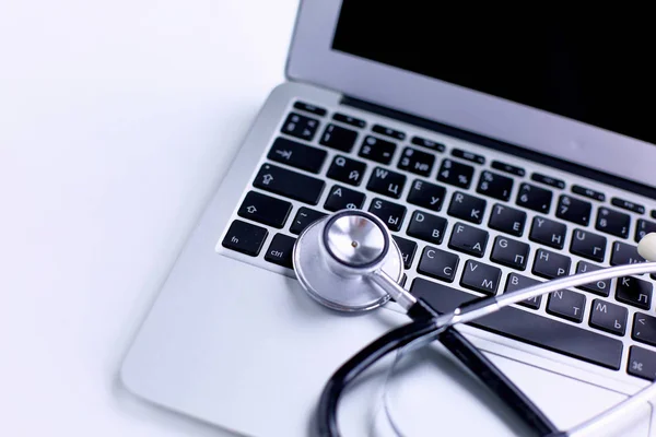 オンライン医学の概念、ノート パソコンのキーボードの上に横たわるまたはコンピューターのトラブルシューティングは聴診器表示コピー スペースとローアングル — ストック写真