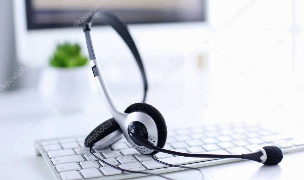 Communication support, call center and customer service help desk. VOIP headset on laptop computer keyboard