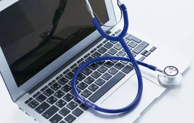 Bir dizüstü bilgisayar klavye online m kavramı içinde yatan stetoskop