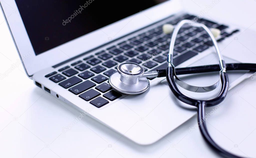 Stethoscope lying on a laptop keyboard in a concept of online m