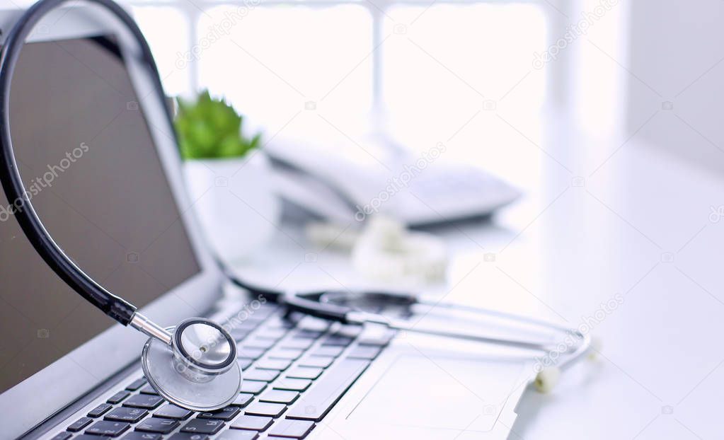 Stethoscope lying on a laptop keyboard in a concept of online m