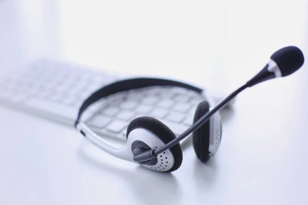 Centro de llamadas y servicio de atención al cliente. Auriculares VOIP en el teclado del ordenador portátil — Foto de Stock