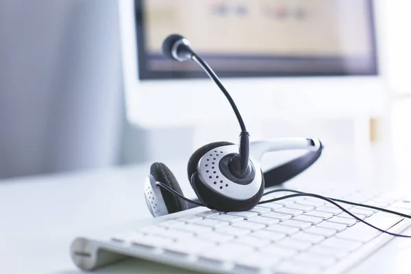Centro de llamadas y servicio de atención al cliente. Auriculares VOIP en el teclado del ordenador portátil — Foto de Stock