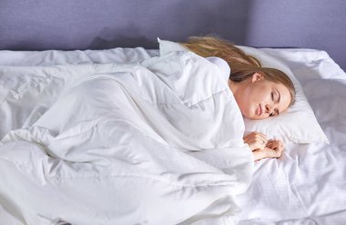 Güzel kız yatakta yatarken yatak odasında, uyuyor
