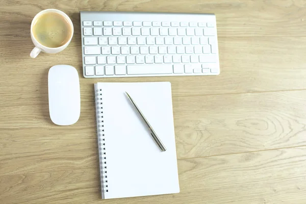 Mesa de escritorio de oficina con teclado de computadora, portátil con pluma y taza de café en el escritorio —  Fotos de Stock