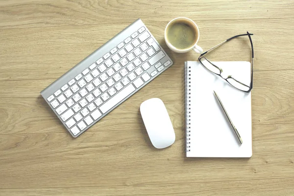Mesa de escritório com teclado de computador, notebook com caneta e xícara de café na mesa — Fotografia de Stock
