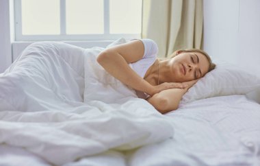 Güzel kız yatakta yatarken yatak odasında, uyuyor