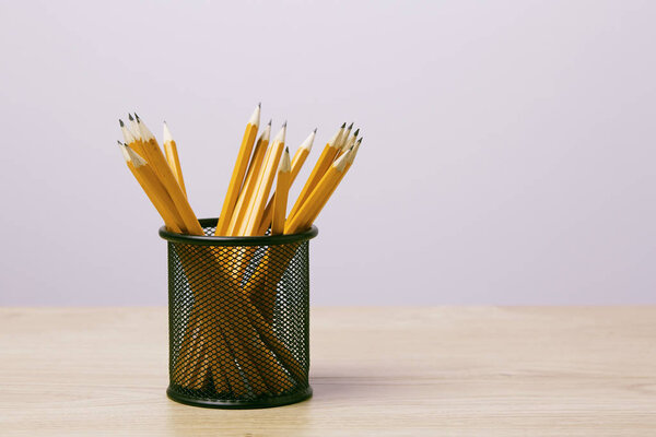 Graphite pencils in a metal grid-container. Concept