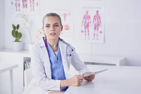 Uma jovem médica numa secretária no escritório. O conceito de saúde e medicina — Fotografia de Stock