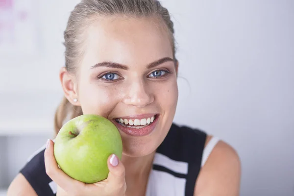 Unga vackra leende flicka med ett grönt äpple i händer — Stockfoto