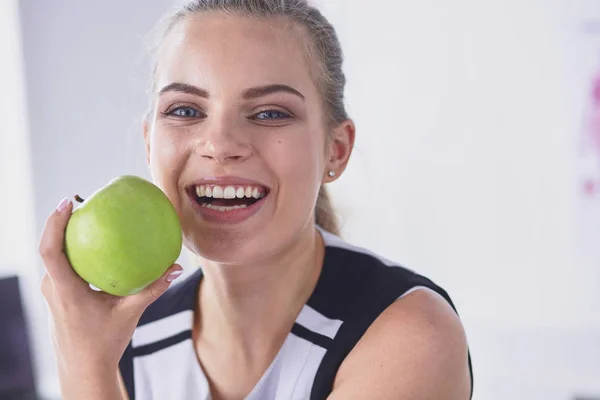 Unga vackra leende flicka med ett grönt äpple i händer — Stockfoto