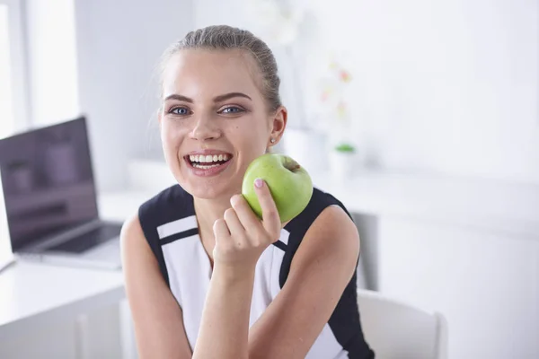 Unga vackra leende flicka med ett grönt äpple i händer — Stockfoto
