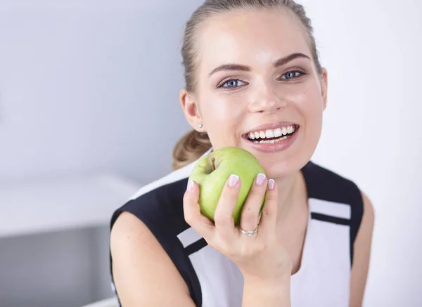 Unga vackra leende flicka med ett grönt äpple i händer — Stockfoto