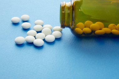 bir kahverengi şişe ilaç beyaz hap