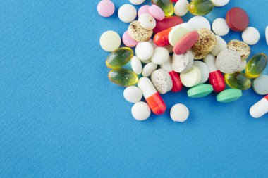 Mavi bir arka plan üzerinde hap saçılmış