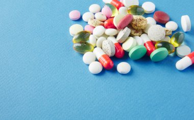 Mavi bir arka plan üzerinde hap saçılmış