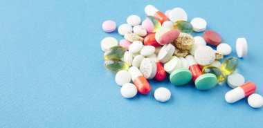 Mavi bir arka plan üzerinde hap saçılmış