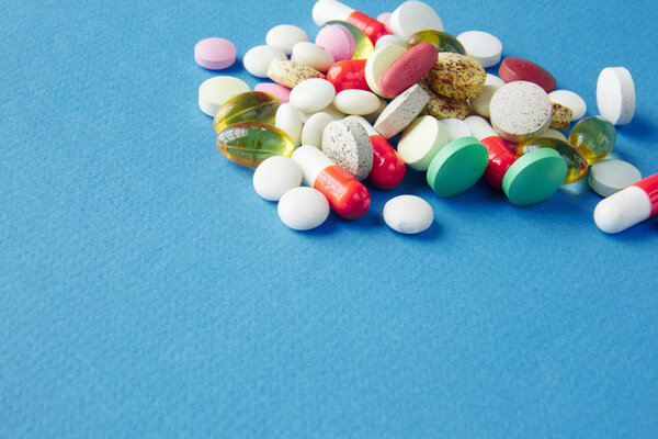 Pills are scattered over a blue background