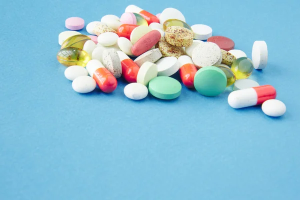 Tabletták vannak szétszórva a kék háttér — Stock Fotó