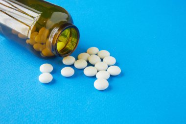 bir kahverengi şişe ilaç beyaz hap