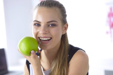 Genç güzel gülümseyen kız elinde bir yeşil elma ile