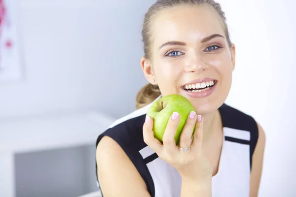 Unga vackra leende flicka med ett grönt äpple i händer — Stockfoto