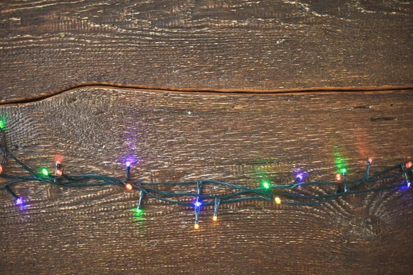 Karácsonyi fények, egy fából készült háttér. Nézd meg felülről — Stock Fotó