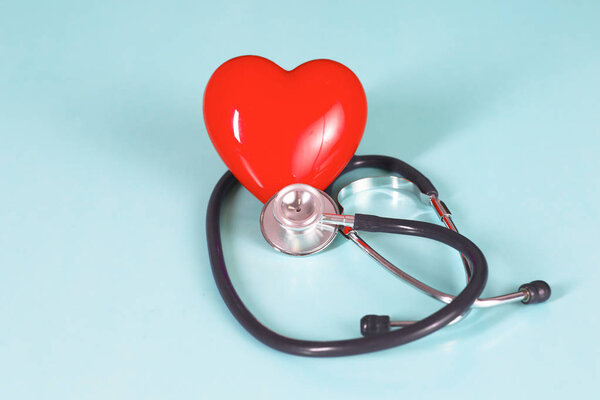 Red heart and a stethoscope on desk