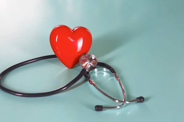 Red heart and a stethoscope on desk — Stock Photo, Image